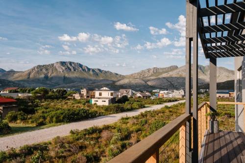 a view from the balcony of a house with mountains in the background at Prinia on Peak in Pringle Bay in Pringle Bay