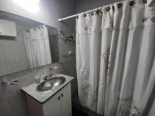 baño con lavabo y cortina de ducha en Departamento Montevideana en Villa Mercedes