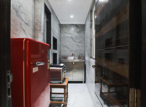 a kitchen with a red refrigerator and a sink at Cosy Grand, Near Chanakyapuri, Embassy Area in New Delhi