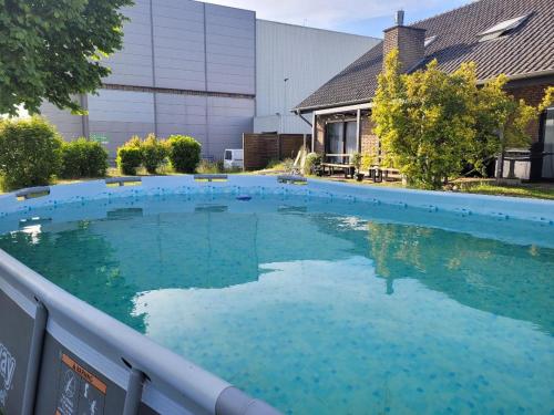 a swimming pool with blue water in front of a building at Hani's Home Gruppenunterkunft in Verl