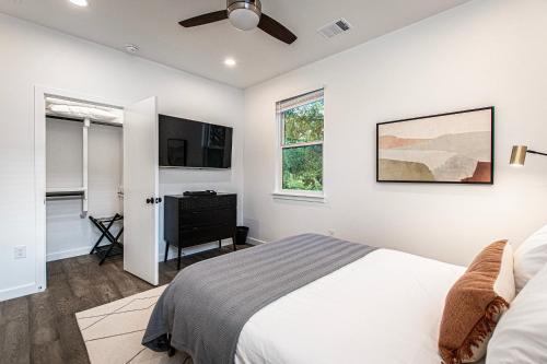 a bedroom with a bed and a flat screen tv at Beautiful 3 Bedroom Unit in Austin