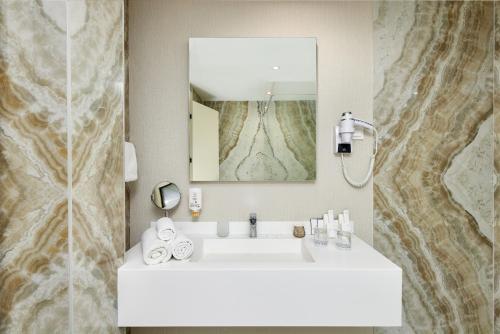 a bathroom with a white sink and a mirror at Hotel Splendido Bay in Tivat