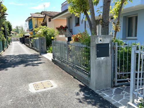 uma cerca em frente a uma casa com uma árvore em La Casina di Zaira em Rimini