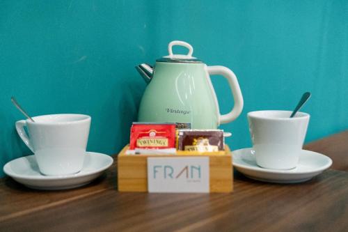 a tea pot and two cups on a table at FRAN CITY SUITE in Vico Equense