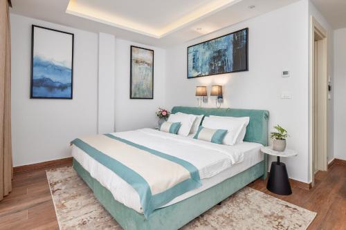 a bedroom with a large bed with white walls at Hotel Splendido Bay in Tivat