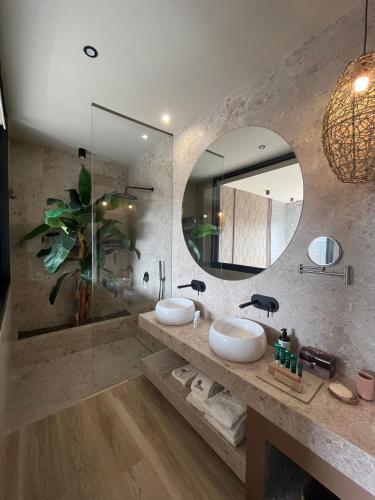 a bathroom with two sinks and a large mirror at Hotel Boutique Varadero in Zahara de los Atunes