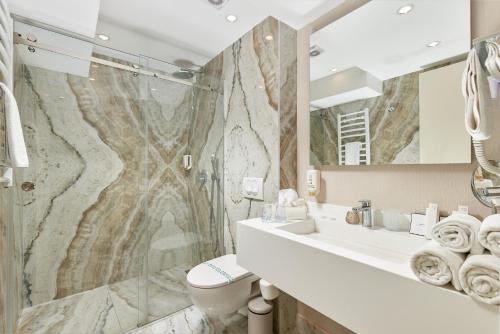 a bathroom with a sink and a toilet and a mirror at Hotel Splendido Bay in Tivat