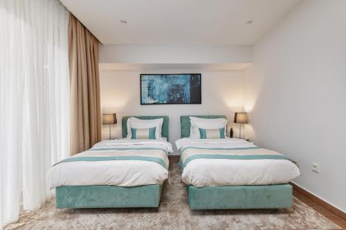 two beds sitting next to each other in a bedroom at Hotel Splendido Bay in Tivat