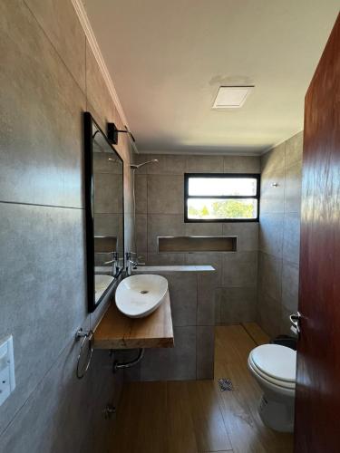 a bathroom with a sink and a toilet at Travesia Sur Hostel in El Bolsón