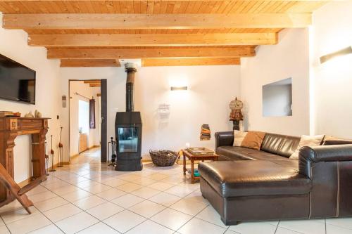 un salon avec un canapé en cuir et une cheminée dans l'établissement Le Domaine de Kerampape, gîte accessible, vignoble en Finistère sud, à Pouldergat