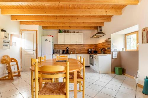 een keuken met een houten tafel en houten plafonds bij Le Domaine de Kerampape, gîte accessible, vignoble en Finistère sud in Pouldergat