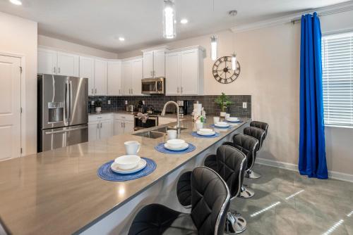 a large kitchen with a long table with chairs at Luxury Lake View 9-Bedroom Villa @Storey Lake Resort in Kissimmee