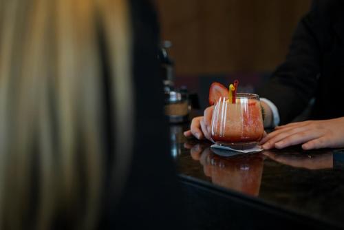 a person holding a cup with a candle in it at Mercure Prishtina City in Pristina
