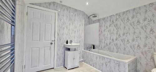 a bathroom with a sink and a toilet and a tub at Bedford Street by Switchback Stays in Cardiff