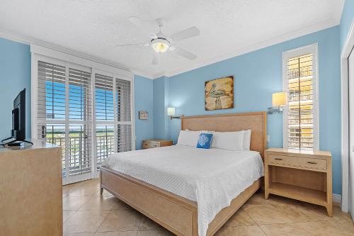 ein Schlafzimmer mit einem Bett und einem Fernseher und Fenstern in der Unterkunft Beach Colony Tower 14A in Pensacola