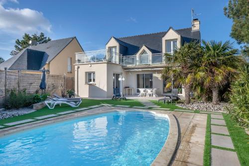 una casa con piscina frente a una casa en Instants de detente, piscine et calme, en Le Pouliguen