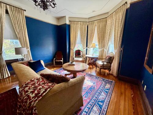 salon z niebieskimi ścianami, kanapą i stołem w obiekcie MacFie House w mieście Cape Girardeau