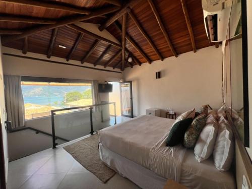 a bedroom with a bed with a view of the ocean at Abricó Beach Hotel in São Sebastião