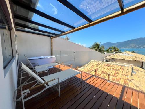 a deck with a chair and a bench on it at Abricó Beach Hotel in São Sebastião