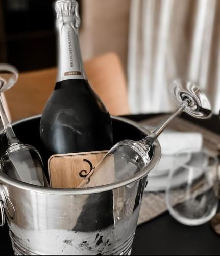 a bottle of wine in a bucket on a table at Suite privée avec sauna et spa à Saint-Fuscien in Saint-Fuscien