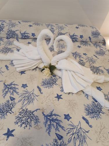 Ein Bett mit zwei Schwänen, die wie Herzen aussehen. in der Unterkunft Casa Acqua Marina Ponza in Ponza
