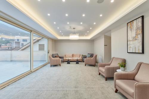 a waiting room with chairs and tables and a large window at Hotel Splendido Bay in Tivat