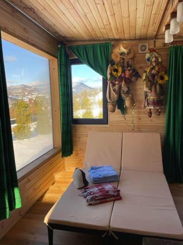 a room with a couch in a room with windows at Grey apartments in Slavske