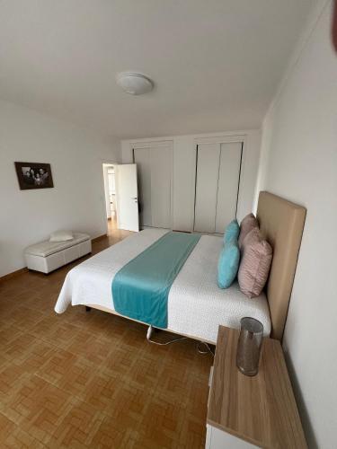 a bedroom with a bed with blue and pink pillows at Casa Amar in Loulé
