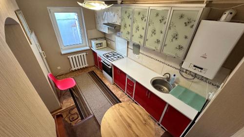 a small kitchen with red cabinets and a sink at Отель "Natali" in Mykolaiv
