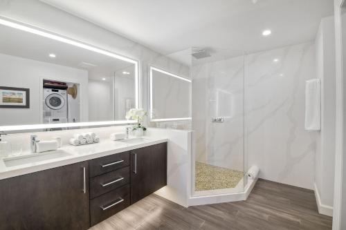 a bathroom with a shower and a sink and a mirror at La Costa Luxury Condo - Fully Remodeled in Encinitas