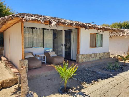 a small house with a thatched roof at Oasis de Vichayito in Vichayito