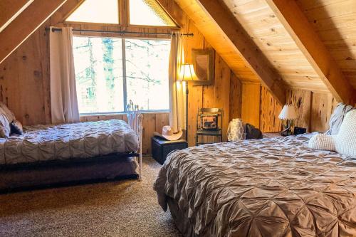 um quarto com 2 camas e uma grande janela em The Woodsy Whimsical Cabin em Big Bear Lake