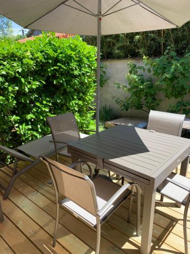 a table and chairs with an umbrella on a patio at LOGIS HOTELS - Hôtel et Restaurant L'Océana in Lanton