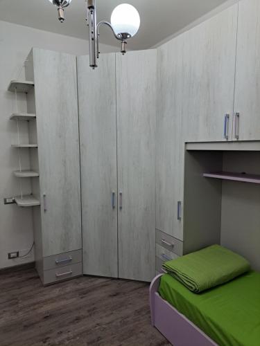 a bedroom with white cabinets and a bed with green sheets at Welcome home in Terni