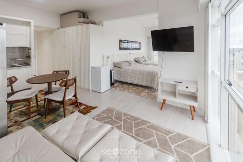 a living room with a bed and a table at Studio cond com piscina 180m hard rock café ESR1912 in Curitiba