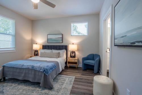 a bedroom with a bed and a blue chair at Entire 6 Bedroom Triplex Home in Austin in Austin