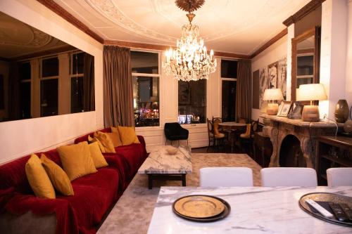 a living room with a red couch and a chandelier at Redlightdistrict chinacitycentre partypalace in Amsterdam