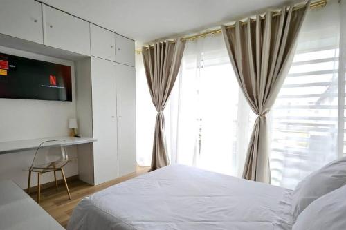 a bedroom with a bed and a large window at L'oiseau du paradis - moderne et élégant in Cayenne