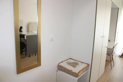a mirror and a stool in a room with a kitchen at L'oiseau de paradis - à deux pas de l'Université de Guyane in Cayenne
