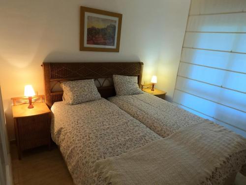 a bedroom with a bed and two lamps on tables at Flat Sleeps 4 with Pool and Terrace in Mijas Costa