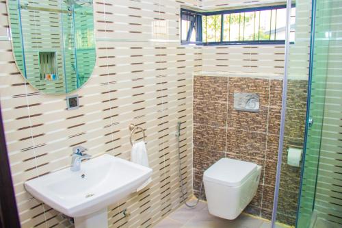 La salle de bains est pourvue d'un lavabo et de toilettes. dans l'établissement Two bedroom lux apartment, à Gwarinpa