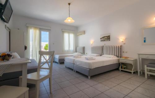 um quarto de hotel com duas camas e uma mesa em Aeolis Hotel em Adamas