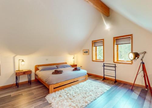 Un dormitorio con una cama y una cámara en un trípode en Woodhaus Aviemore Lodge en Aviemore