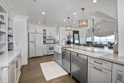 a large kitchen with white cabinets and a large island at Luxury Ocean Views - 6 BR Home - Steps to Sand in Carlsbad