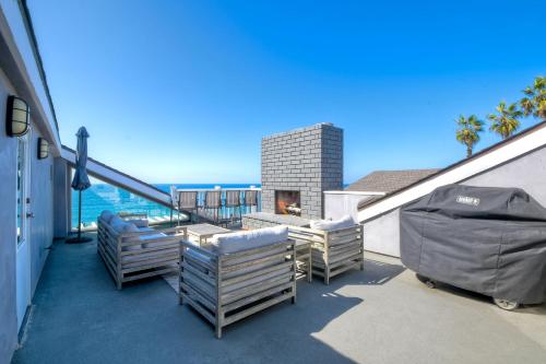 a balcony with chairs and a fireplace on a building at Luxury Ocean Views - 6 BR Home - Steps to Sand in Carlsbad