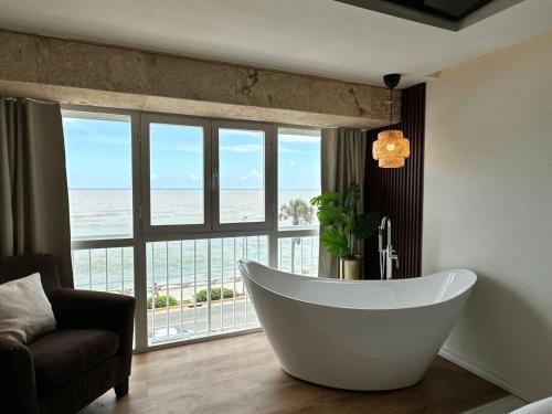 a bath tub in a room with a view of the ocean at Villa Marbella by Potenza Rentals in Santo Domingo