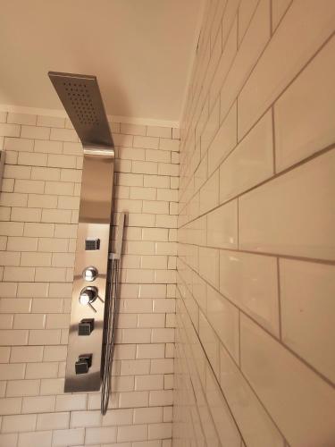 a bathroom with a white tiled wall at Casa Vidal Guesthouse in Tupungato