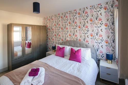 a bedroom with a large bed with pink pillows at Entire Home, 2 Bedrooms - Private with FREE PARKING in Oxford in Oxford