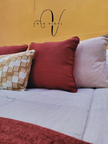 a bed with two pillows and a sign on the wall at Casa Vidal Guesthouse in Tupungato