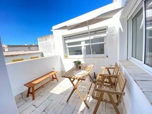 a balcony with two chairs and a table and a swing at Buhardilla en calle Ancha, pleno centro in Sanlúcar de Barrameda